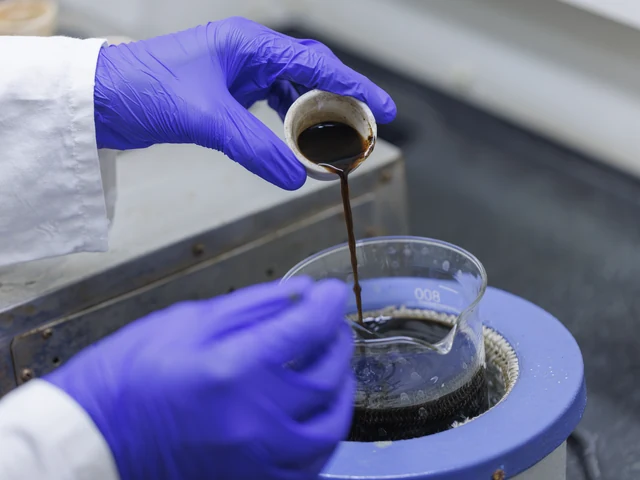 Scientist in a lab coat pouring a sample into a beaker