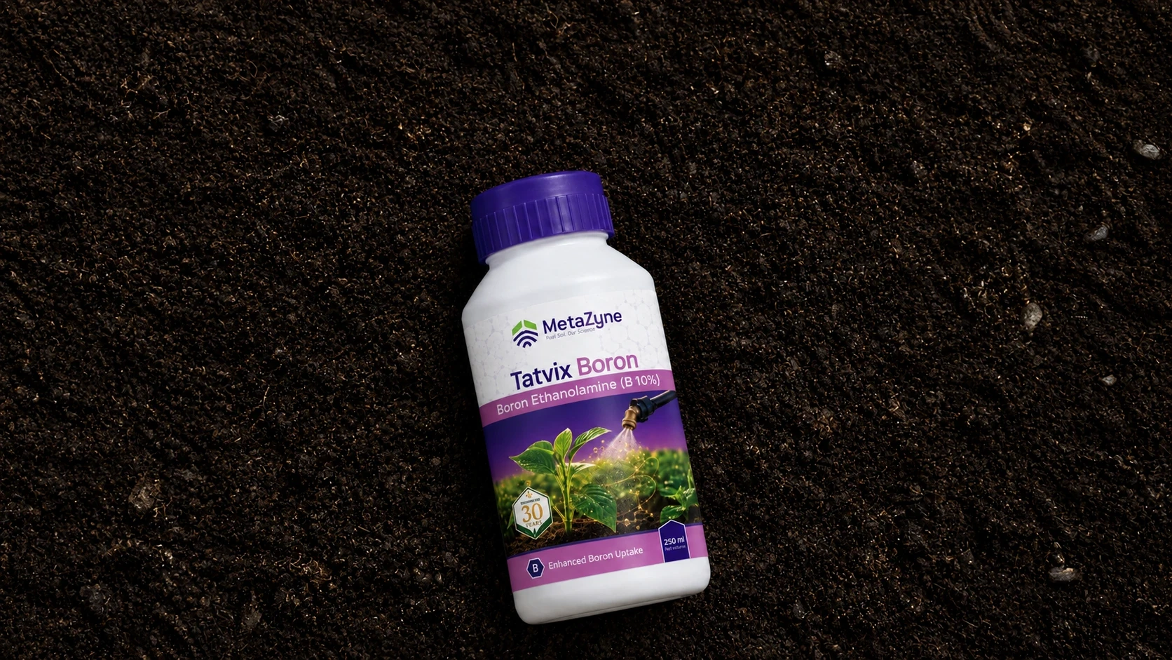 Tatvix Boron bottle lying on dark soil, label showing a foliar spray nozzle over a seedling